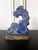 A Chinese scholar rock carved from a natural lapis stone and displayed on a brocade wrapped stand circa late 19th century...