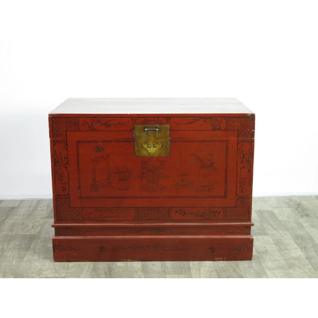 This red storage trunk is decorated with faded hand painted objects and rich patina and texture. This red Asian accent...