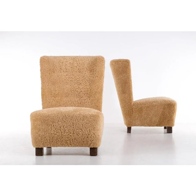 Excellent condition. Newly reupholstered in honey colored sheepskin.