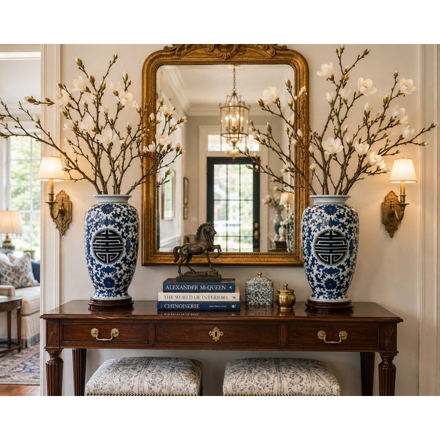 A striking pair of blue and white Chinese Export style porcelain baluster vases featuring richly detailed scrolling floral...