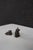 Pair of sterling silver cat figurines, each depicting a cat in a different pose. One figure features a reclining cat with...