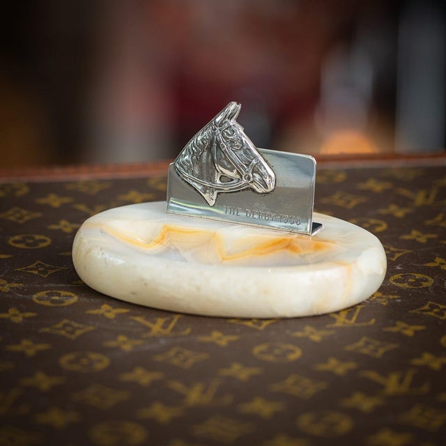 A charming 20th century silver ashtray, combining natural onyx with a sporting theme closely associated with british...