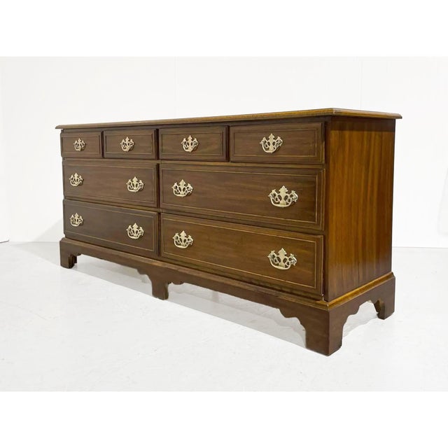 A traditional mid-century American-made dresser from the Hampton Court furniture line by Dixie Furniture.The solid wood...
