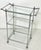 Three tiered drinks trolley in polished chrome with beveled glass shelving. In the style of Maison Jansen, unmarked but...