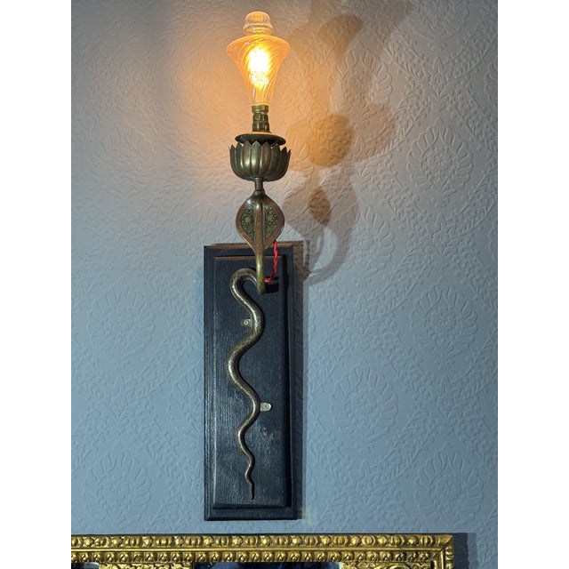Beautiful brass wall sconces in the form of a cobra with black and red enamel detailing Mounted on wood plaque and with...
