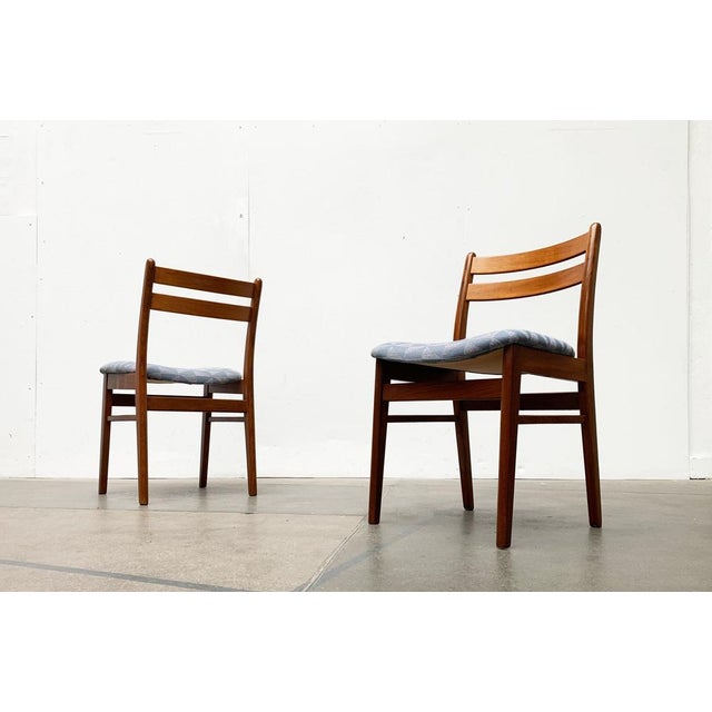 2 chairs with a striking pattern. The cushion shows a minimalist pattern of geometric shapes in gray and blue. Signs of...