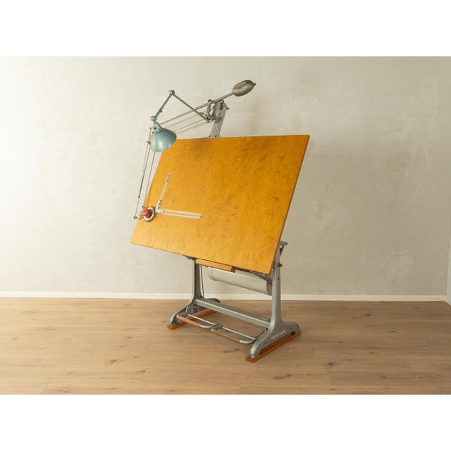 Unique 1950s drafting table. High-quality cast iron construction with a drawing board and lamp. The frame is height-...