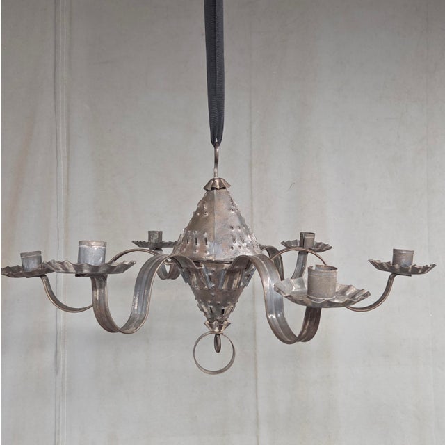 A charming antique early 1900s traditional punched tin New Mexican Spanish Colonial style six-arm candle chandelier. The...