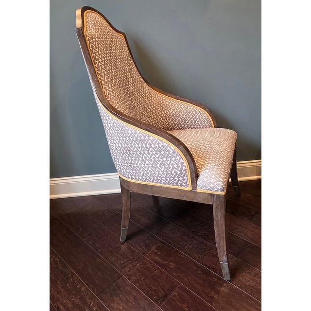 This accent chair has an exposed wood frame and is upholstered in a fabric from the Fermoie collection with a contrast...
