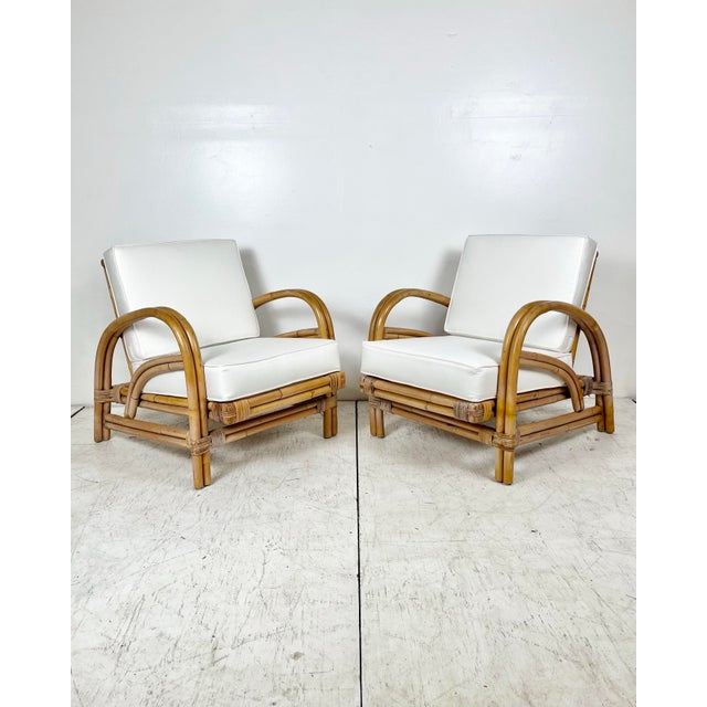 Vintage pair of rattan lounge chairs. Bent rattan deco horse shoe style. Smaller scale chairs that are still perfect for...
