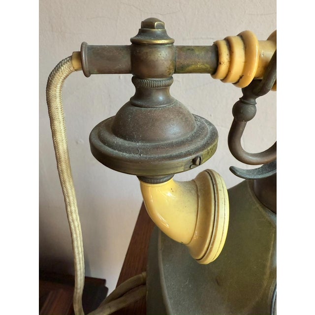 Vintage mid century rotary telephone with brass base and cream tone handset. Cradle form with rotary dial inset, designed...