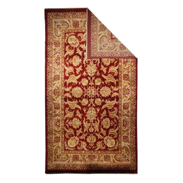 The very dark red field shows a central 16-point rosette medallion organizing a vigorous petal palmette and flamboyant...