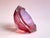 The body of the ashtray is made of clear glass, while the interior is cranberry pink. The contrast between the clear and...