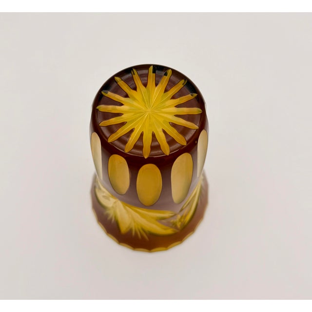 A striking Bohemian Czech cut-to-clear art glass vase featuring a rich amber-brown overlay intricately wheel-cut to reveal...