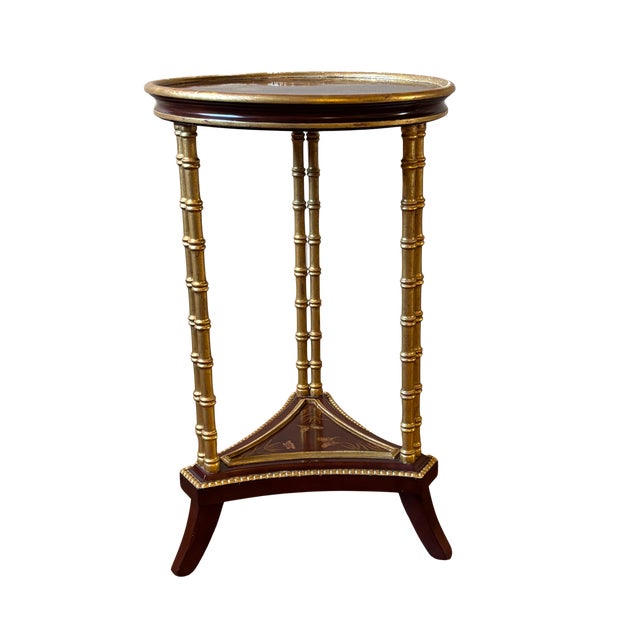 Planked round top with gallery edge detail and three pairs of faux bamboo legs, one shelf at bottom. Chinoiserie depicting...