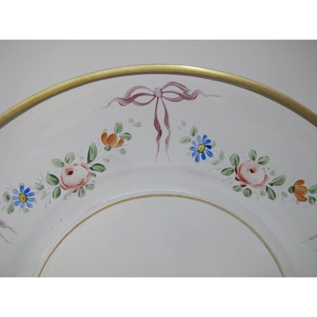 Very sweet vintage plate. Clear glass with hand painted halo of colorful flowers and bows. Rim has gold gilt accent....