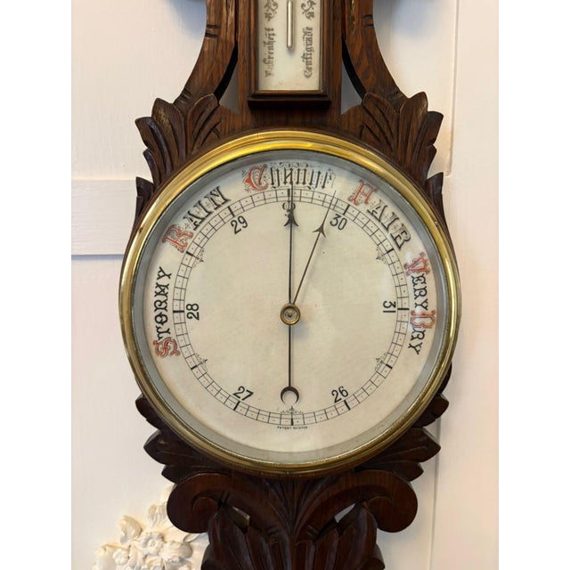 A very decorative antique carved oak aneroid barometer with integrated thermometer, mounted on a finely shaped backplate....