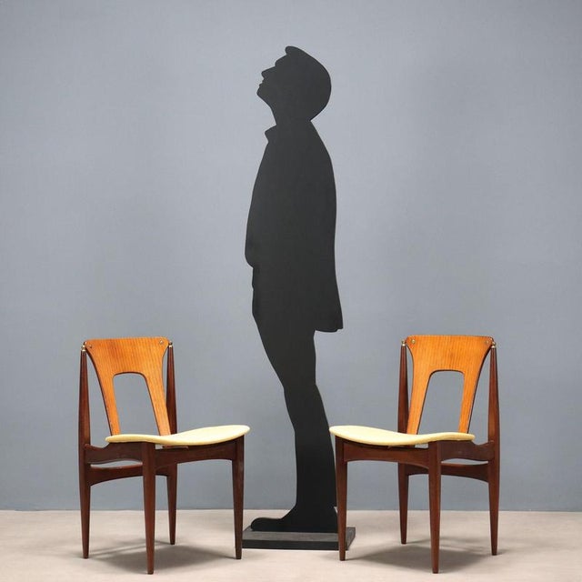 Group of four vintage dining chairs with wooden frame and yellow fabric seat. This piece is attributed to the mentioned...