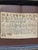 Antique needlepoint sampler in tramp art frame. Handkerchief size with multiple stitched fonts of the alphabet and...