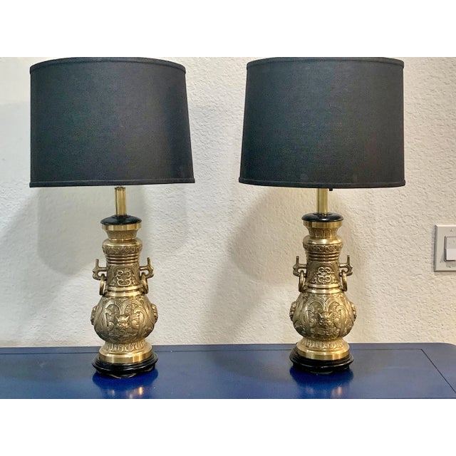 Mid-century bronze table lamps Pepe Mendoza style. Featuring ebonized bases, loose rings on the sides with an Oriental jar...