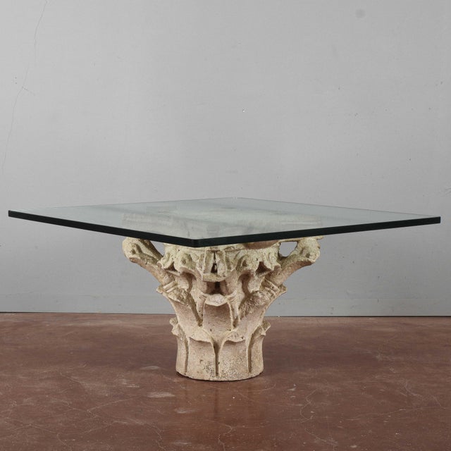This coffee table is a distinctive piece that blends antique and modern, thanks to its base made of a white stone capital....