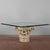 This coffee table is a distinctive piece that blends antique and modern, thanks to its base made of a white stone capital....