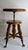 Antique H. Holtzman & Sons adjustable swivel piano stool featuring an ornate carved wood tripod base, turned and reeded...