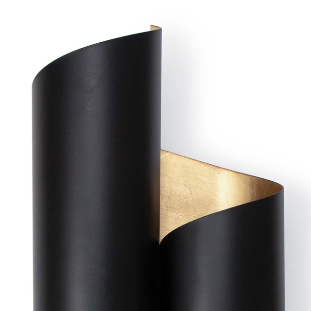 The Folio Sconce's exterior is uniquely contrasted by its almost paper-like metal that has been expertly formed to achieve...