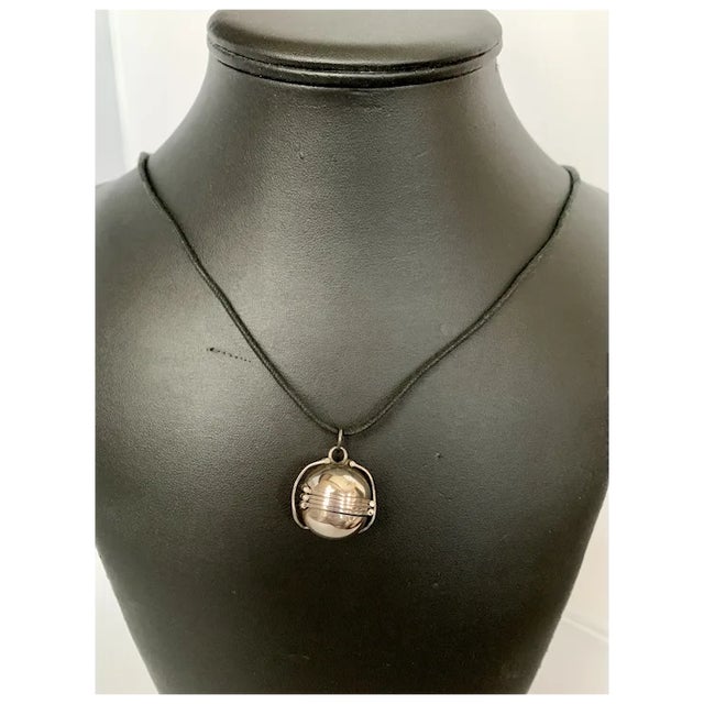 Sterling ball or sphere locket. Features 6 places for pictures to be artfully folded and secured into a ball. Suspended...