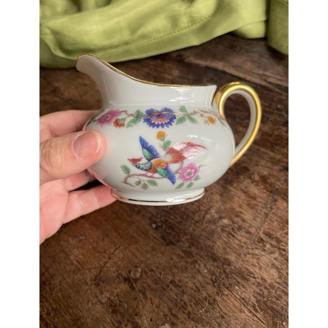 lovely French porcelain creamer presented in a bird of paradise pattern that is vibrant and colorful. Around the rim,...