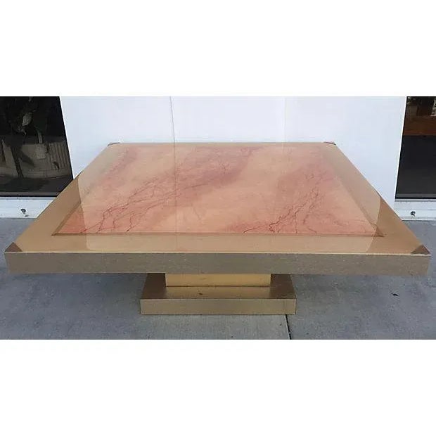 Interesting faux marble painted square coffee table with top covered in resin. Base is covered in a brushed brass metal as...