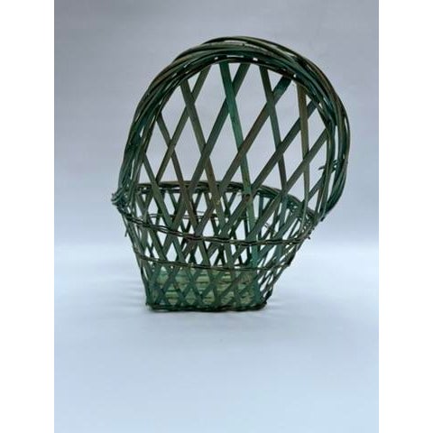 A single vintage small woven wicker or straw basket with an unusual shape suitable for hanging.