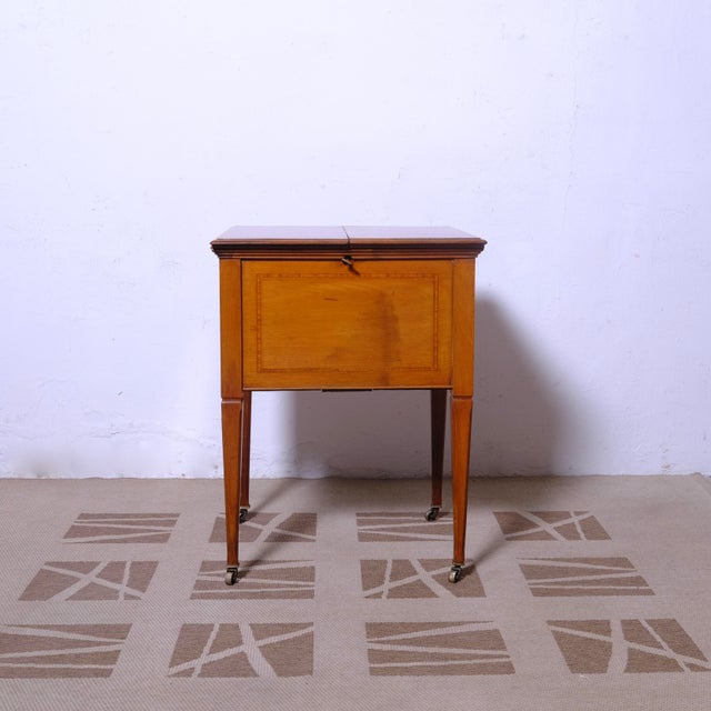 Beautiful and refined Victorian-era English bar cabinet, on casters, made by Hobbs and Co. Once opened, there are various...