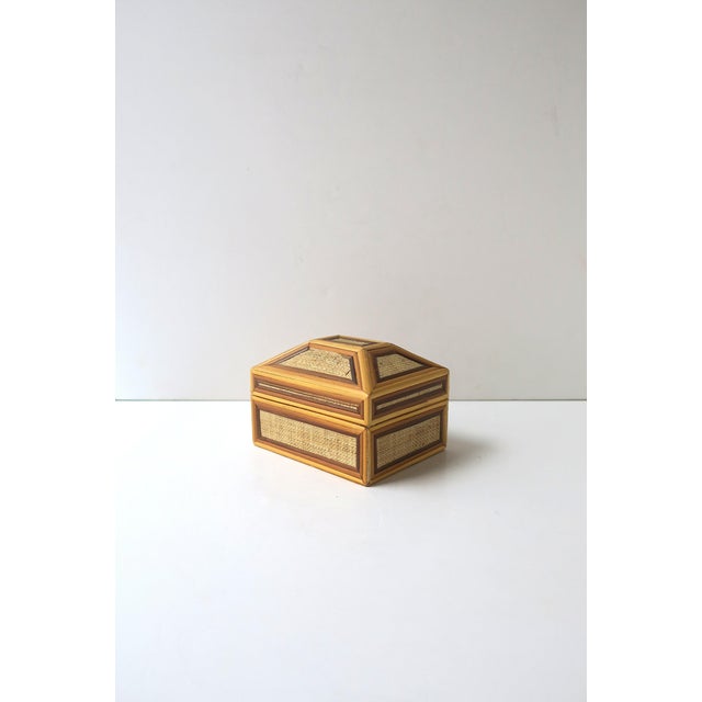 A chic vintage wicker and linen jewelry or trinket box with a stepped, multi‑panel hinged lid, in the Modern style, circa...