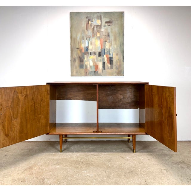 A gorgeous mid century modern two-door walnut cabinet circa 1960’s. Suitable for use as a standard credenza or sideboard...