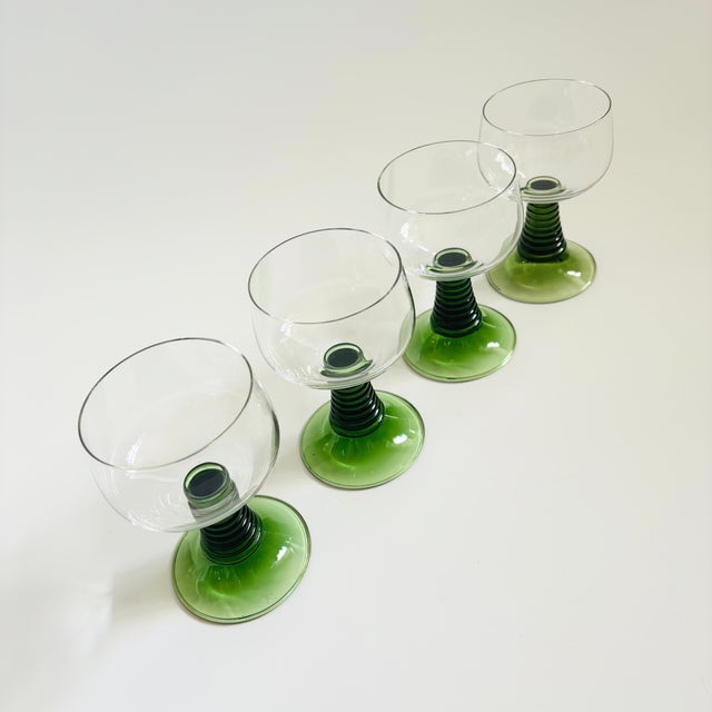 A set of 4 vintage German roemer wine glasses. Each with a clear coupe shaped top and classic ribbed stems in a green...