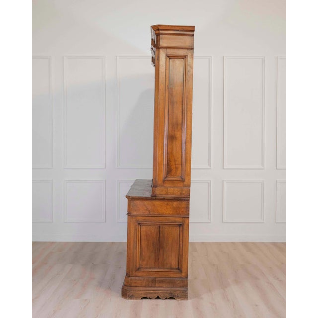 A handsome Italian 19th century walnut bookcase of exceptional scale and architectural presence, crafted in two parts with...