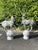 A striking pair of large cast-iron stag and deer garden sculptures, each depicted standing gracefully upon a spherical...