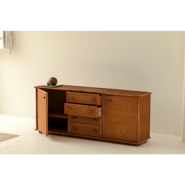 Sideboard produced in Italy around 1970. This cabinet has a bamboo frame with a rattan surface. The inside is finished in...