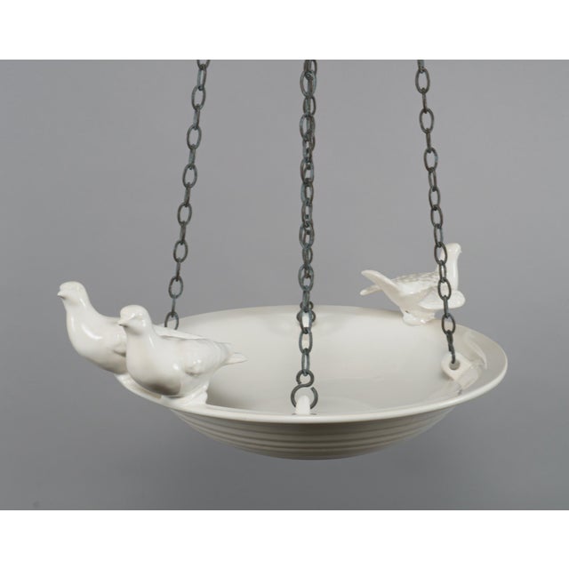 A vintage hanging bowl of stoneware glazed in a creamy off-white, decorated to the rim with sculptural birds, and...