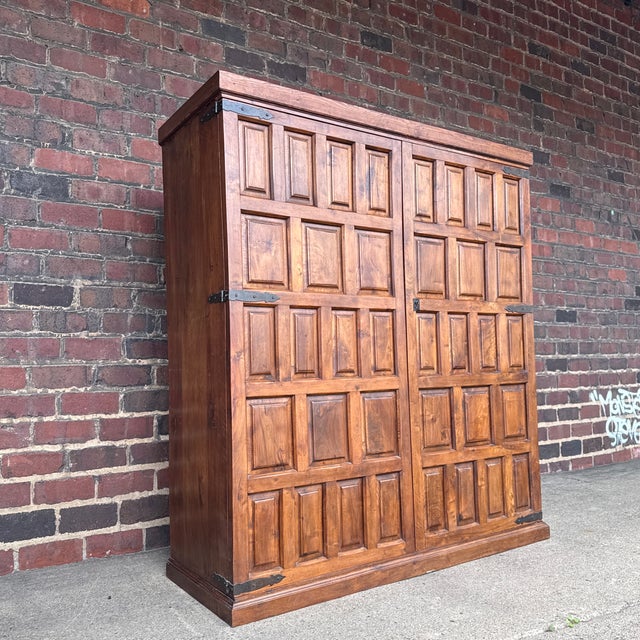 Belgian brutalist oak cabinet featuring a bold geometric paneled façade and hand-forged wrought iron strap hinges. The...