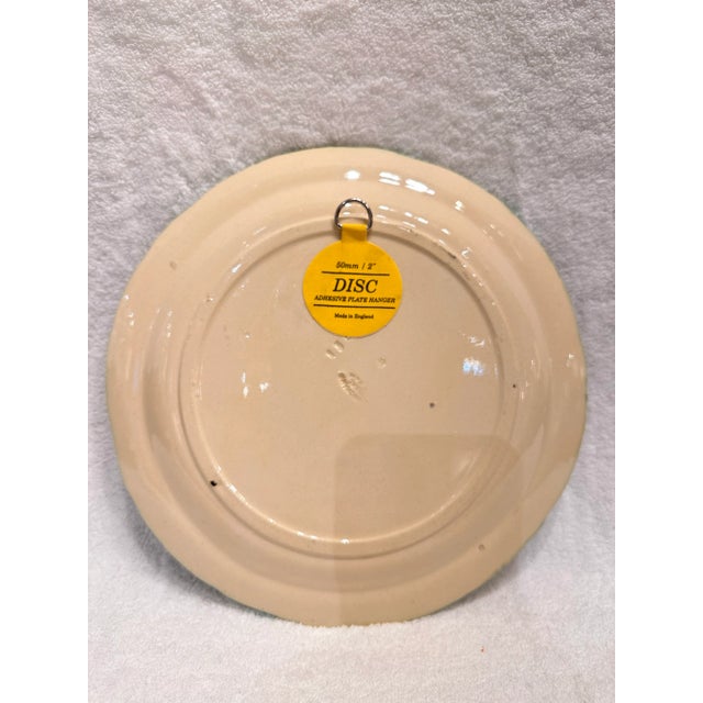 This is such a unique twist on the typical majolica style plate! The base of this plate is a soft cream. The center has...