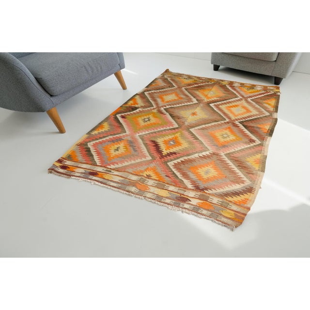 This is a vintage Turkish Oushak rug from the Mid 20th Century. The piece was hand-knotted.