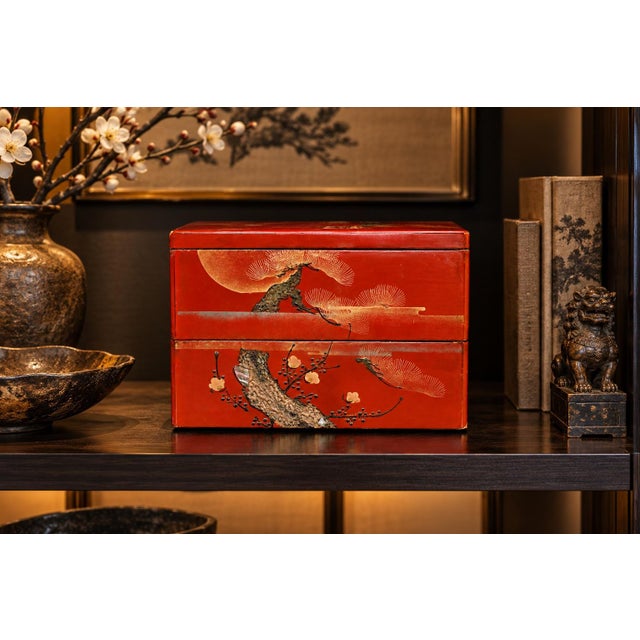 A beautiful Japanese antique two-tiered red lacquer box (jubako), decorated with traditional maki-e techniques, including...