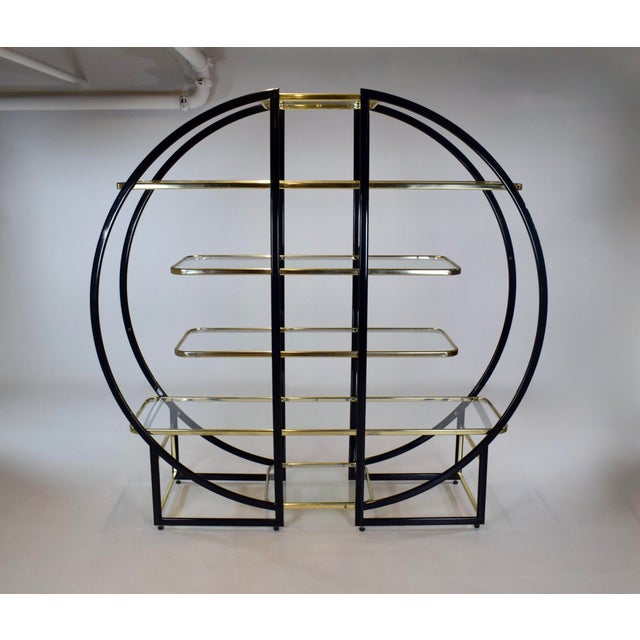 An impressive Maison Jansen style round étagère or vitrine with six glass shelves in a frame of brass and black lacquered...