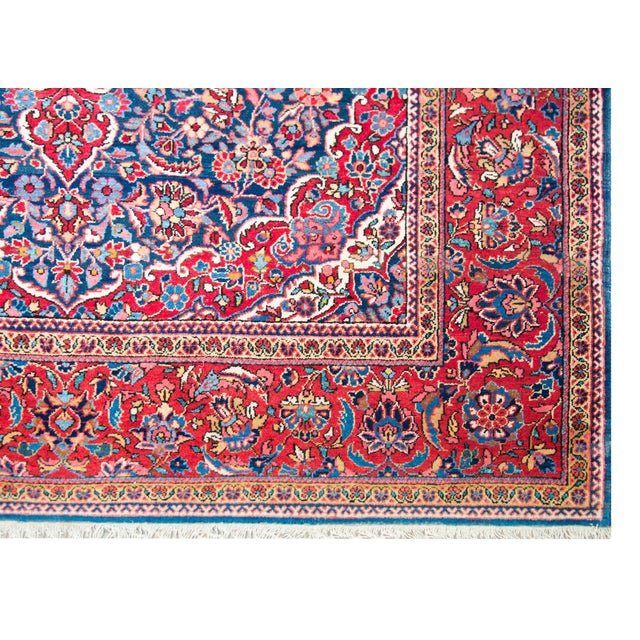 A striking early 20th century Persian Kashan rug with a central medallion living amidst a field of tightly woven flowers...