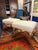 Pair of custom ottomans. Composed of acrylic lucite and upholstered in a woven cream colored bucle style fabric. The...