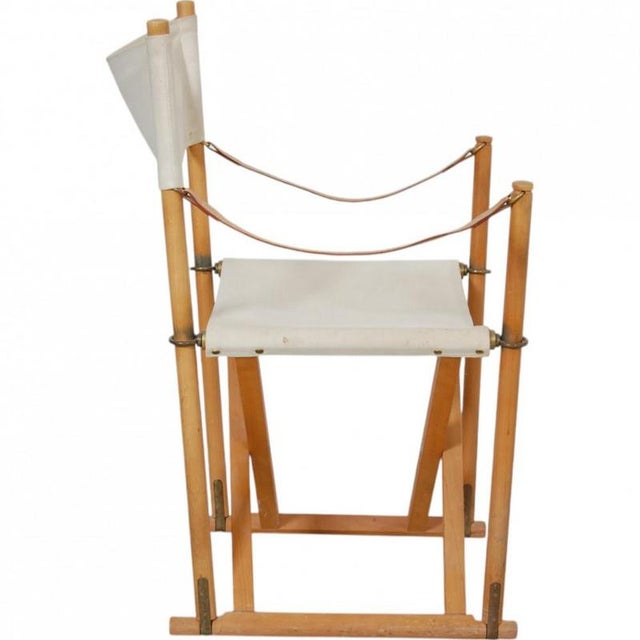 Mogens Koch folding chair with a frame of elm and back and seat upholstered in canvas fabric, and armrests of natural...