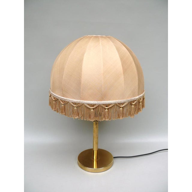 An elegant table lamp made in Germany in the 60s. Thanks to the beige silk lampshade, the lamp emits a pleasant and glare-...