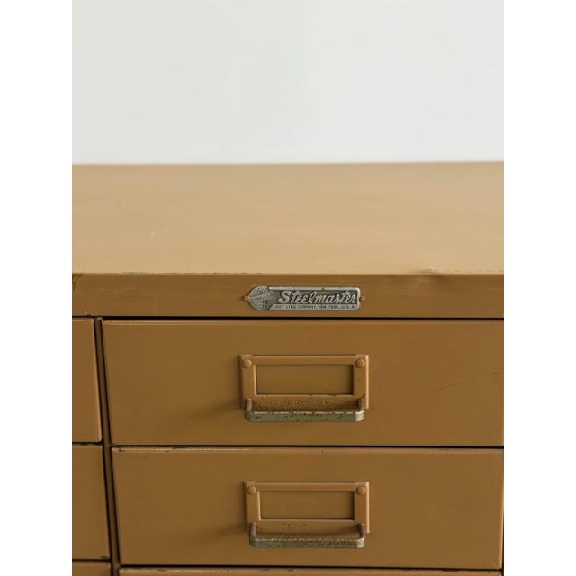 H37 W30 D12 D13 w/ handles This vintage Steelmaster metal cabinet features a grid of compact drawers finished in its...